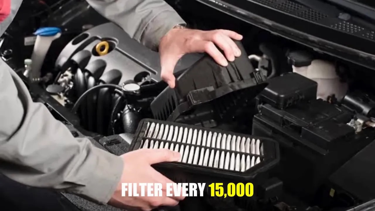 Hands holding a rectangular pleated air filter beside an open air filter housing