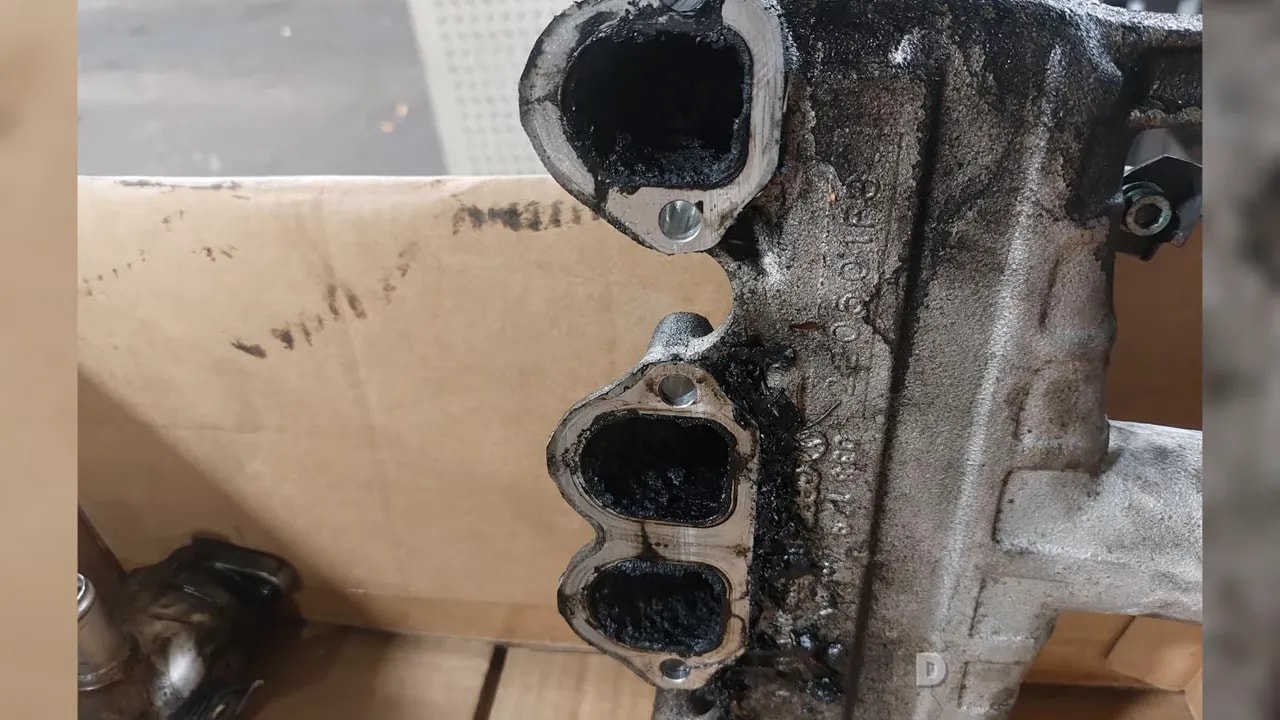 Removed EGR valve with thick black deposits around its opening