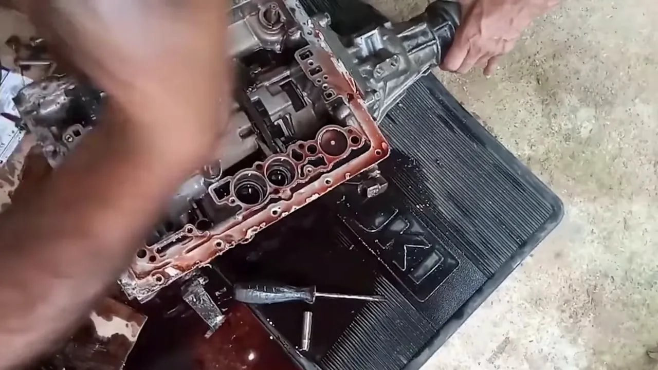 Hand holding a diesel injector above a workbench with other injectors