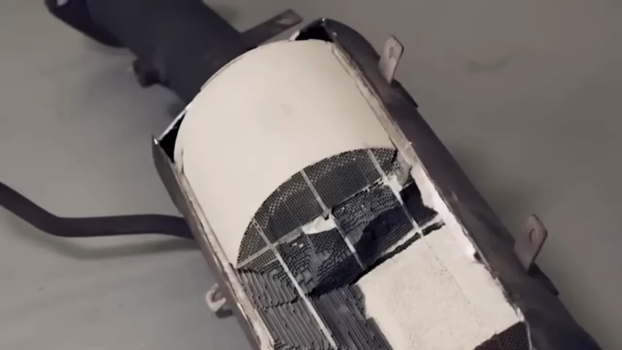 Cutaway exhaust filter housing exposing internal honeycomb sections and surrounding insulation