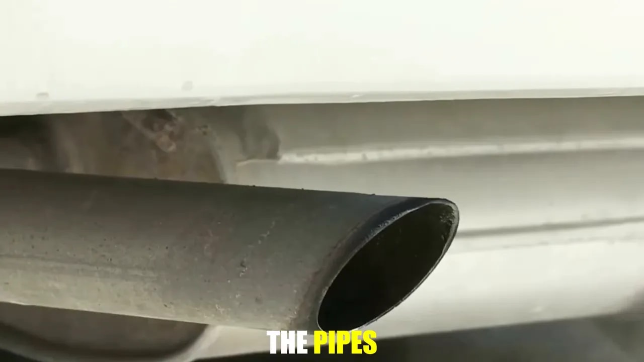 Close-up of an exhaust outlet with a dark interior beneath a rear bumper
