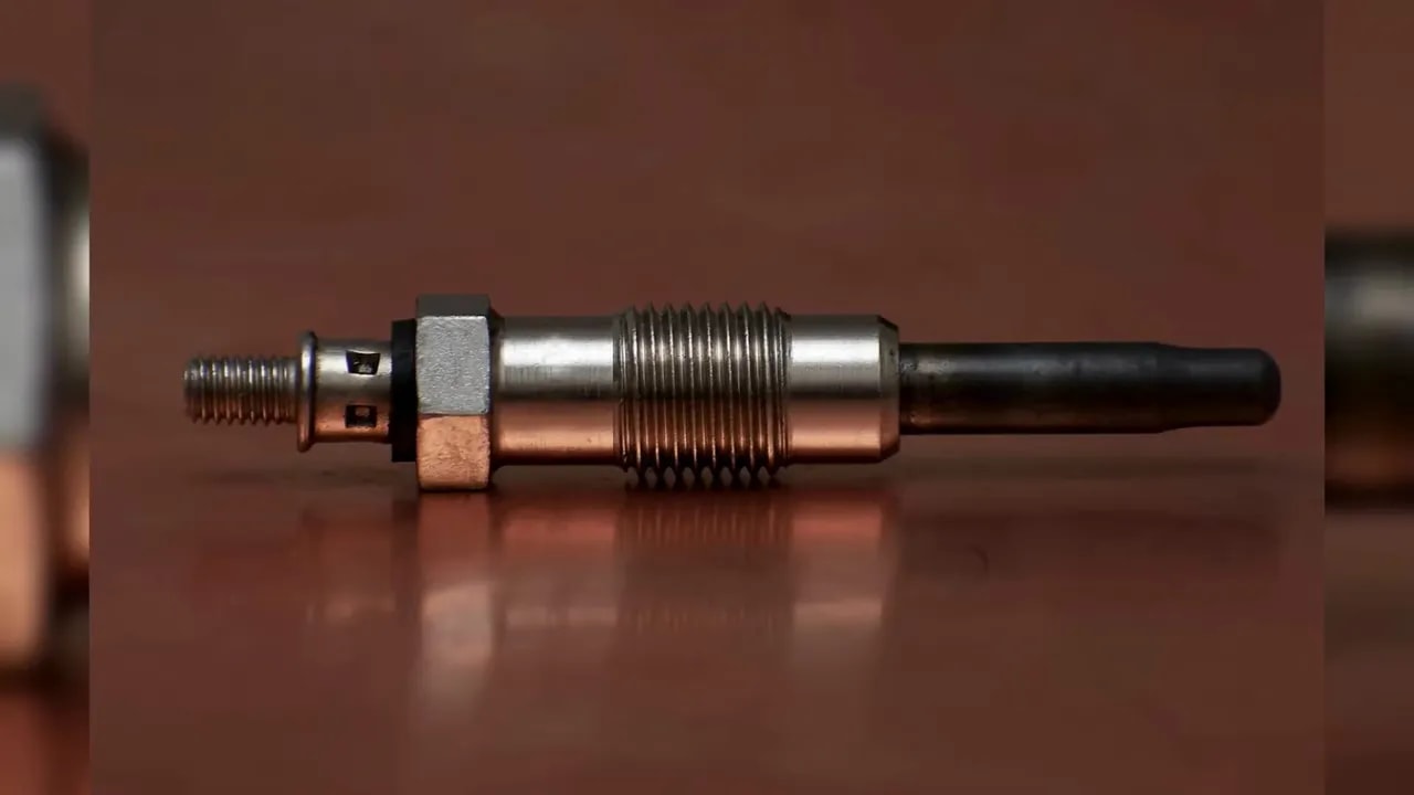 Glow plug showing its terminal, threaded body, and dark heating tip
