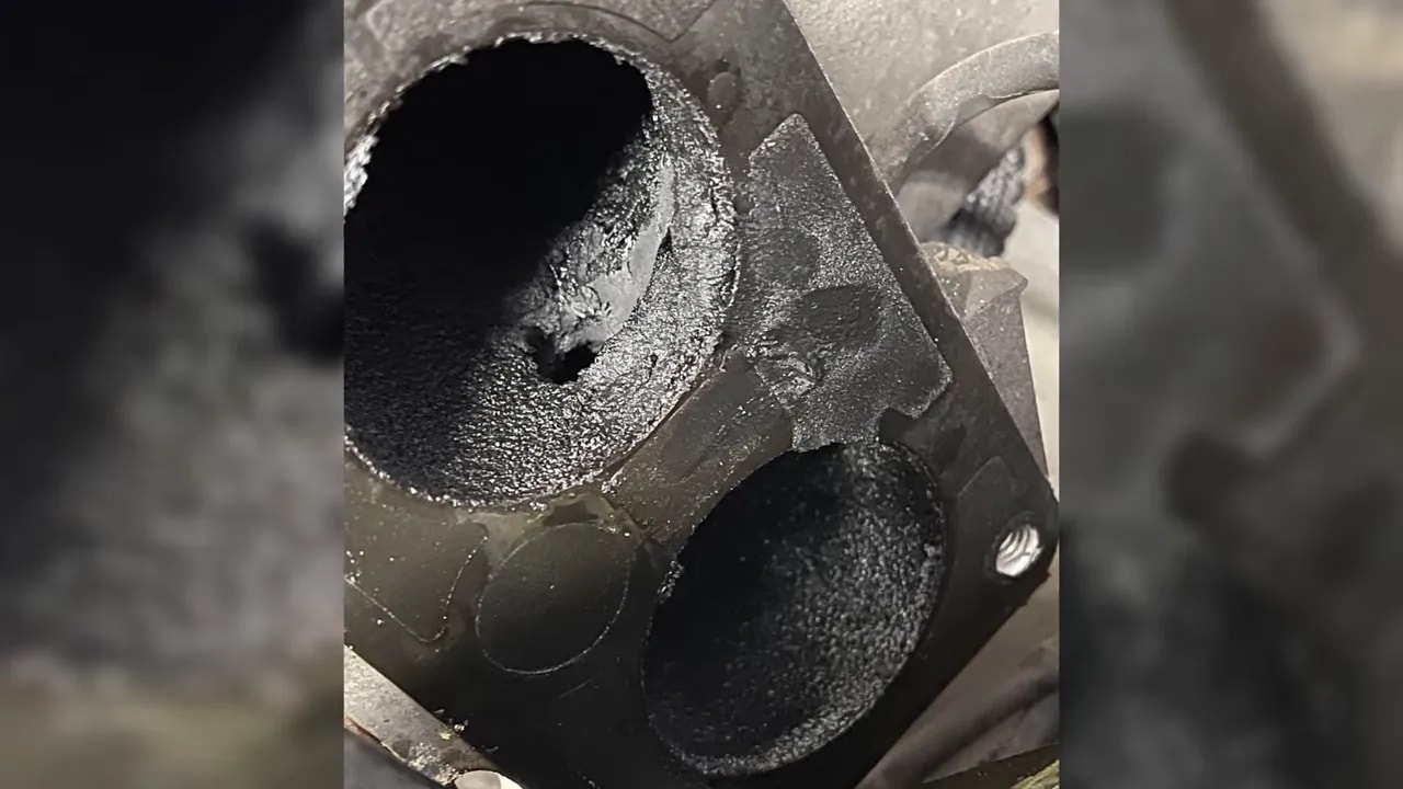 Close-up of an intake opening lined with thick dark deposits