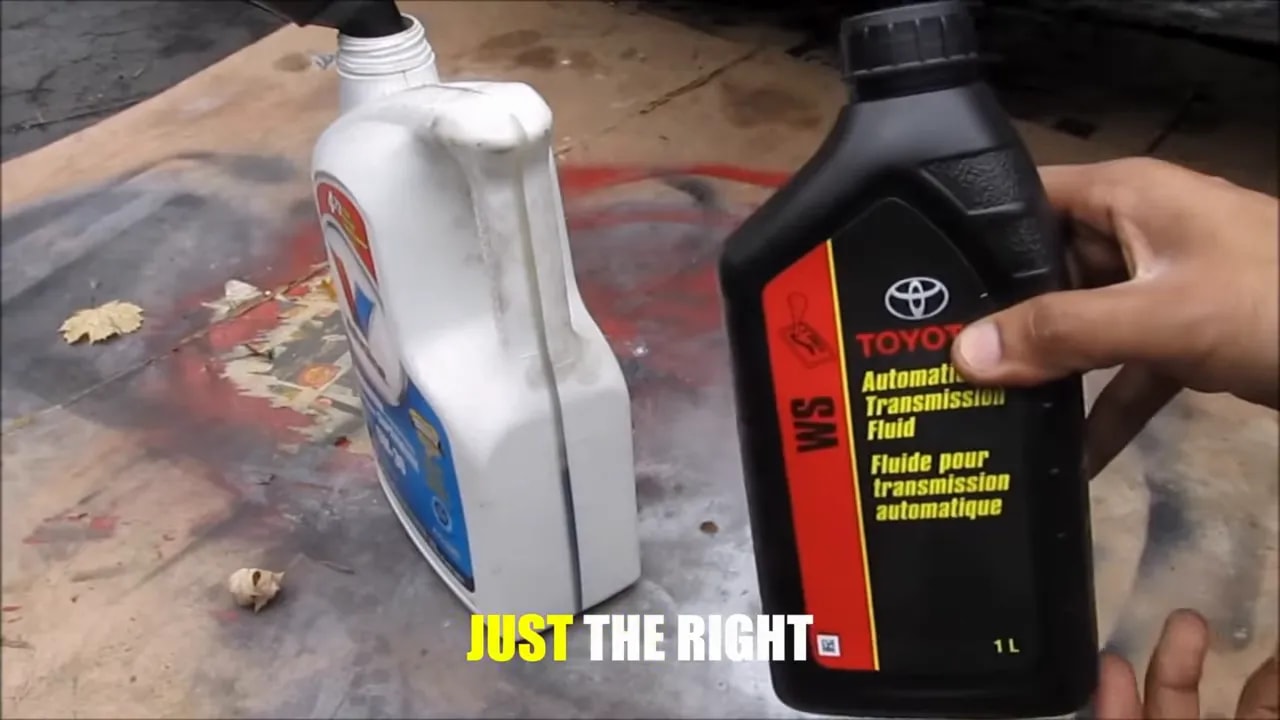 Hands holding a Toyota WS automatic transmission fluid bottle beside a white container
